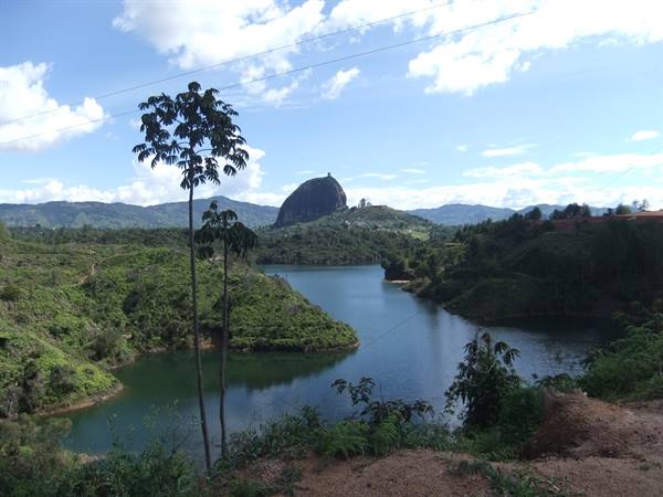 Green lake between hills with the huge Peñón de Guatapé rock