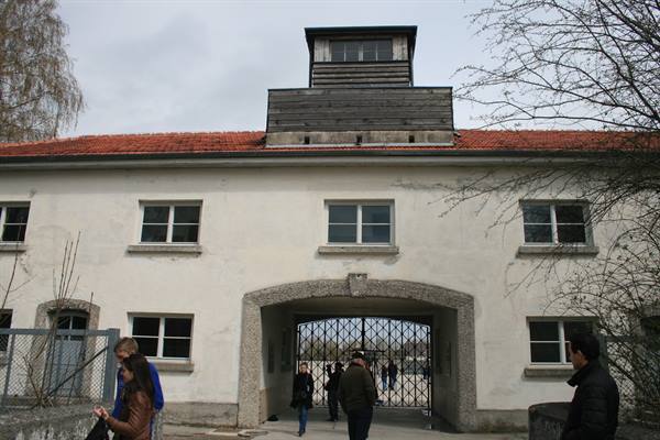 Visitors walk through the iron gate at the Dachau memorial entrance
