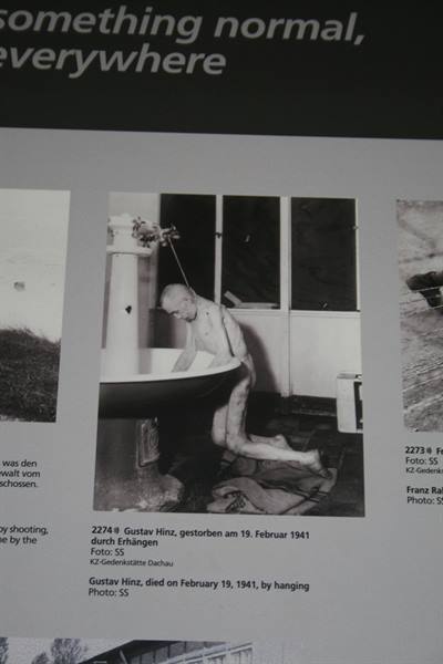 Exhibition panel displaying black and white photograph of prisoner in courtyard