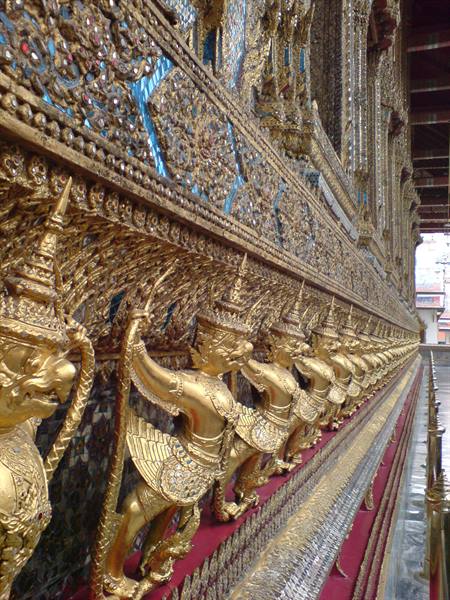 Rows of golden garuda statues along the temple base at Wat Phra Kaew