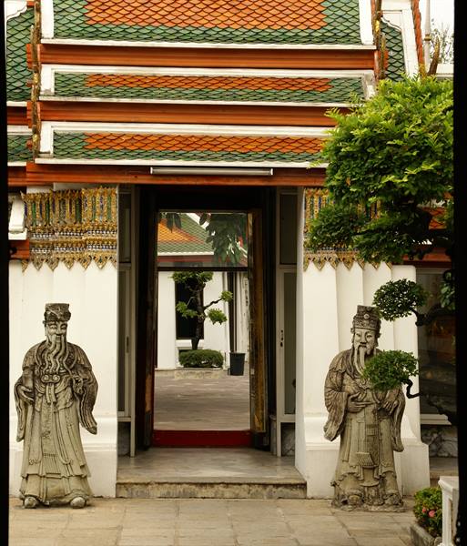 Stone guardian statues flanking the temple gateway at Wat Pho