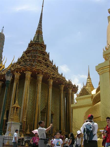Tourists photograph the golden temple spire at Bangkok's Grand Palace