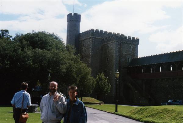 Two tourists pose in front of the stone tower of Cardiff Castle