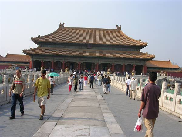 Tourists walk across the marble bridge toward the Forbidden City gate