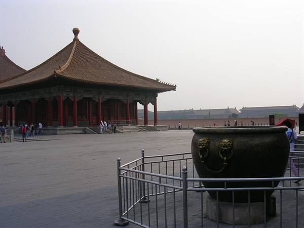Large bronze urn in front of the golden-roofed pavilion in the Forbidden City