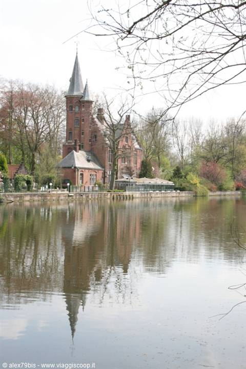 Red brick castle with tower overlooking the lake, reflections and bare trees