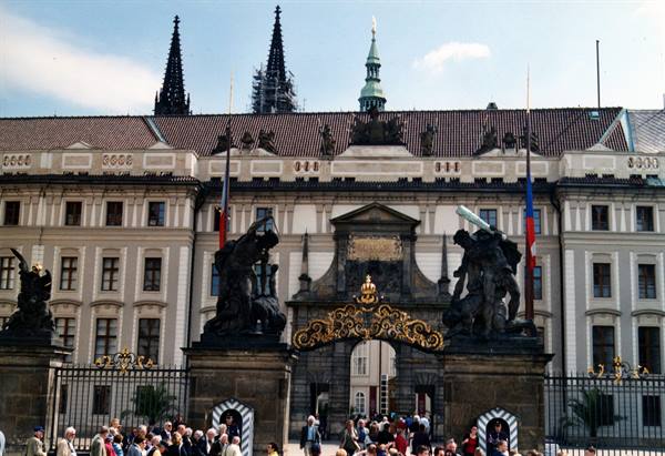 Tourists in front of Prague Castle gate with battling statues