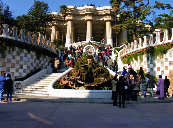 Tourists on the mosaic staircase of Park Güell, Barcelona, sunny light