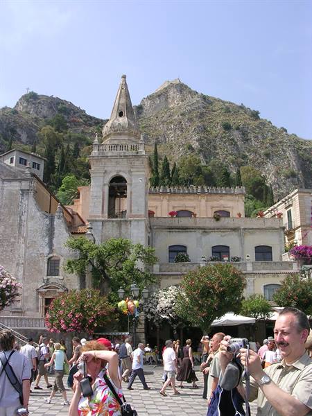 Tourists taking photos in the square with San Giuseppe church, Taormina