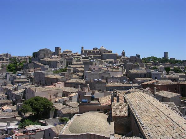 Stone rooftops and domes of Erice under blue sky
