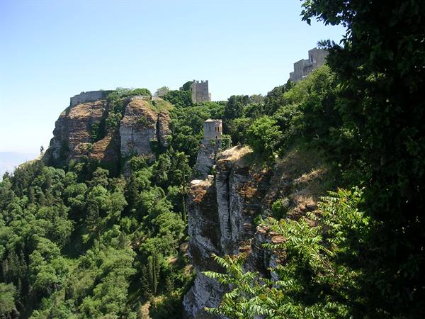Erice castle, medieval walls on rocky cliff under bright sunlight