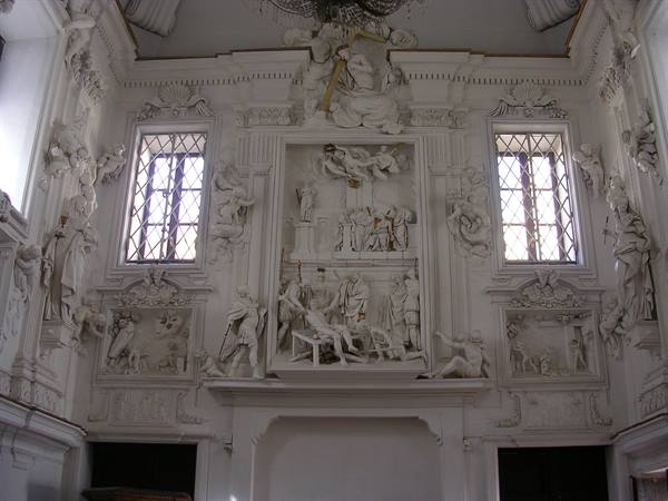 Oratory with white stucco reliefs between two lattice windows