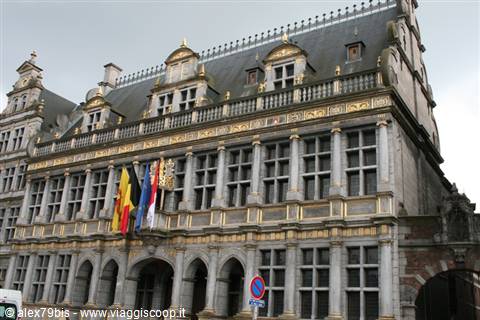 Ghent Town Hall, gothic stone facade with gilded ornaments and flags