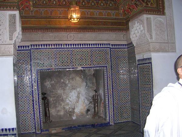 Fireplace with blue zellige mosaic and carved stucco under painted ceiling and lantern