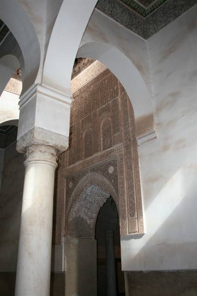 Marble columns and carved stucco arches inside the Ben Youssef Madrasa
