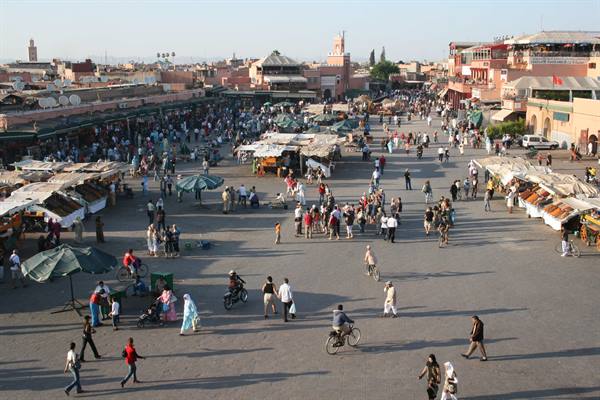 Crowds and bicycles on Marrakech's Jemaa el-Fna square in afternoon light