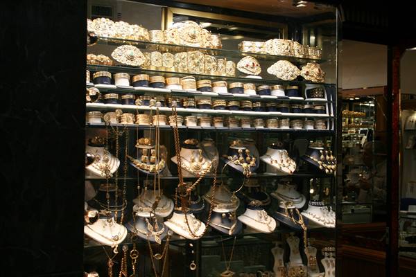Jewelry shop window displaying golden necklaces and bracelets under warm light