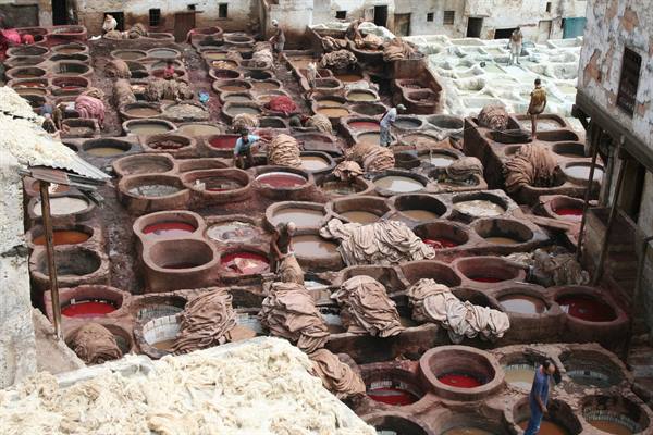 Chouara tannery in Fes, workers among stone vats filled with dyes