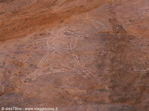 Rock carving of a human figure on reddish stone