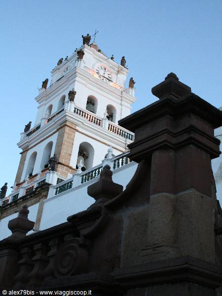 White bell tower with clock and statues of Copacabana Basilica