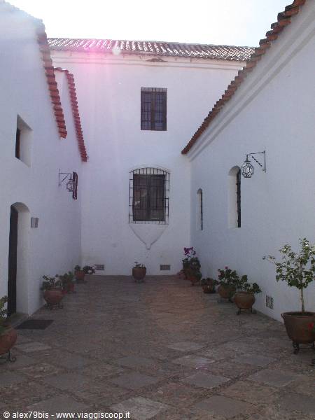 White colonial courtyard with flower pots and wrought iron lanterns