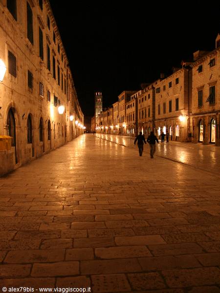 Stradun in Dubrovnik at night, illuminated stone paving, two people walking