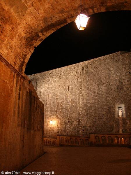 Lantern under stone arch lights the ancient walls at night