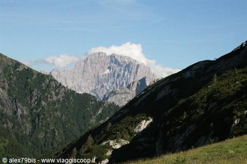 Dolomite massif above forested slopes, clouds wrapping the rocky peak