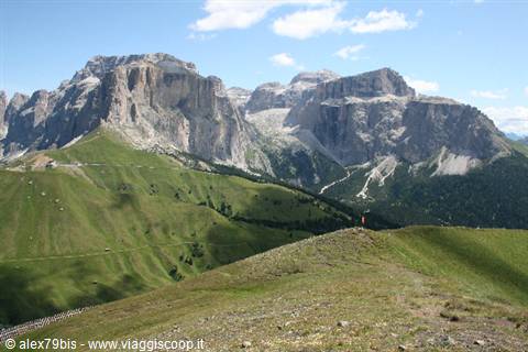Green meadows beneath the rocky Sella Group cliffs, Dolomites