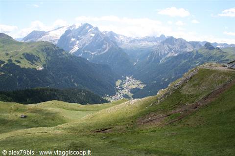 Green meadows overlooking Canazei village beneath the Dolomites