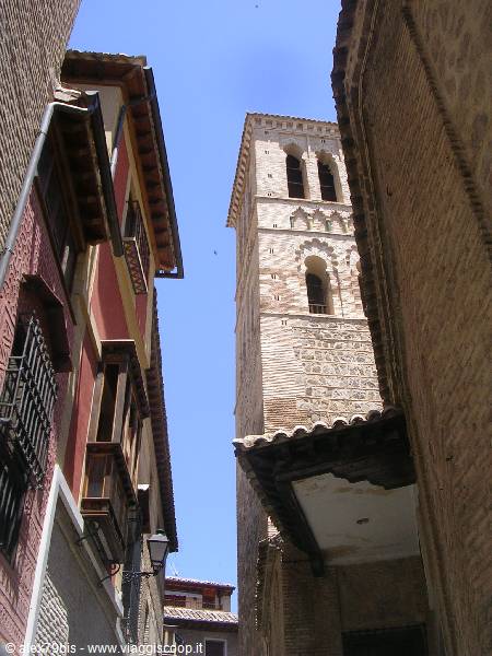 Brick Mudéjar tower rising between old houses in Toledo