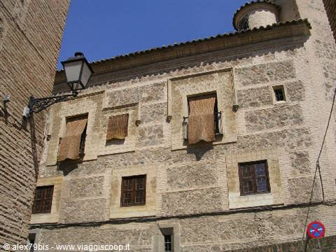 Stone and brick facade with mudejar windows and street lamp, Toledo