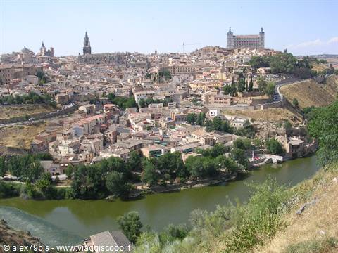 Toledo: the Alcázar on the hill, old houses and the Tagus river in sunlight