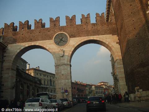 Porta Borsari in Verona: Roman stone gate with battlements and clock, traffic below