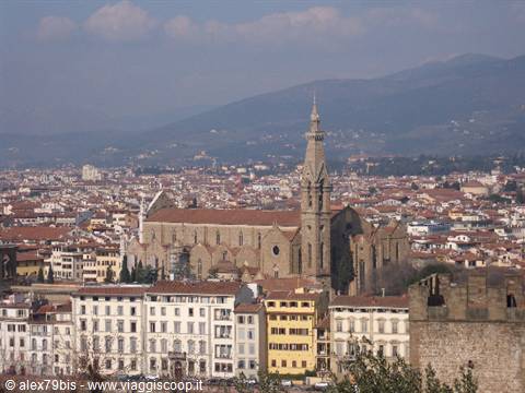 Basilica of Santa Croce in Florence among rooftops, hills in the background