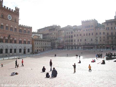 People sitting on Siena's brick square among medieval buildings under soft light