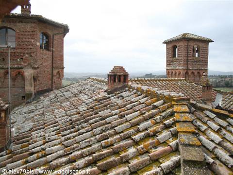 Mossy terracotta rooftops and brick towers under grey sky