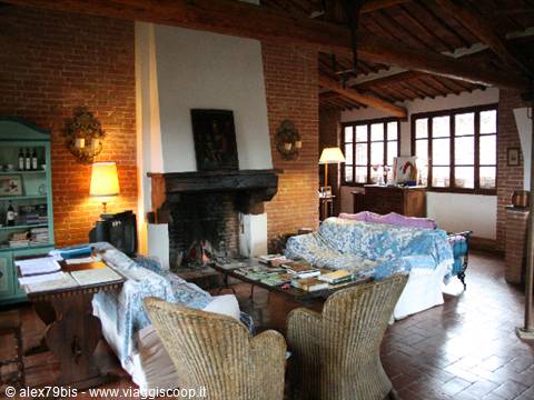 Rustic living room with brick fireplace, wooden beams and covered sofas