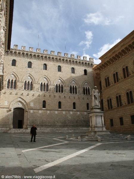 Statue in front of Palazzo Salimbeni, Siena, daylight breaking through clouds