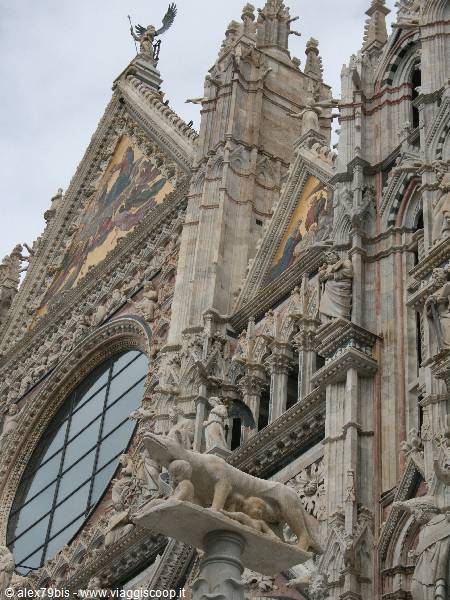 Gothic facade of Siena Cathedral with mosaics and the marble she-wolf statue