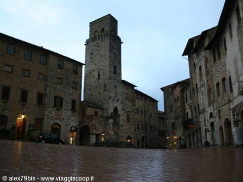 Piazza del Duomo in San Gimignano with medieval tower under cloudy sky