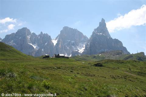 Mountain hut on green meadow beneath the Pale di San Martino peaks, Passo Rolle