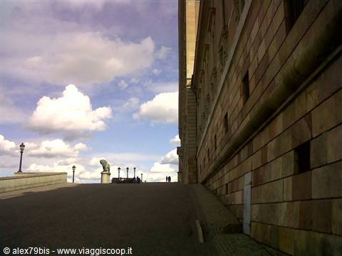 Stone lion statue in front of Stockholm City Hall under white clouds