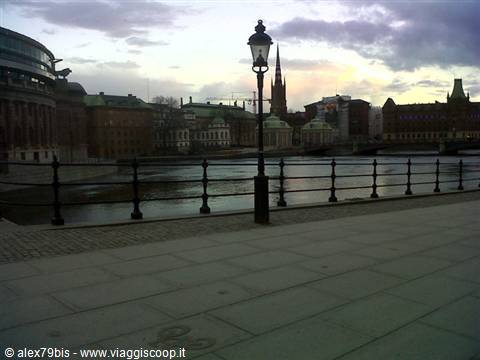 Black lamppost on Stockholm waterfront, Riddarholmen church among rooftops