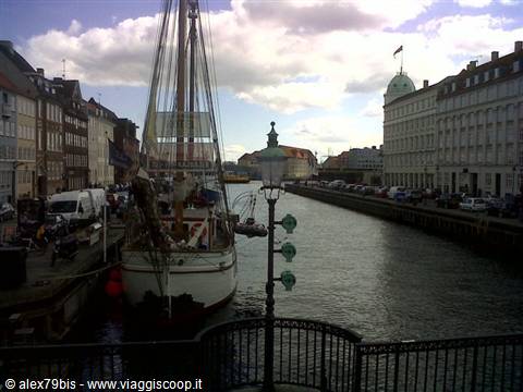 Sailing ship moored along the Nyhavn canal among colorful townhouses