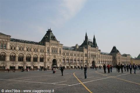 Tourists walk across Red Square in front of the GUM department store, Moscow