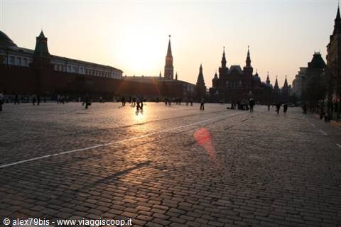 Red Square in Moscow, tourists walk across cobblestones in low sunlight