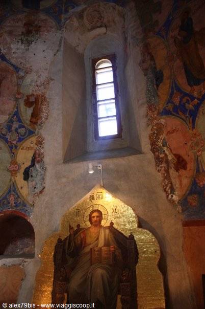 Golden mosaic of Christ enthroned inside a frescoed church