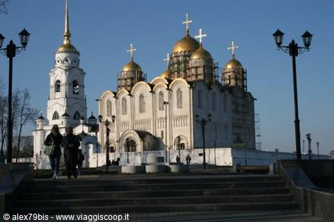 Tourists walk down the steps in front of Vladimir's golden-domed Dormition Cathedral