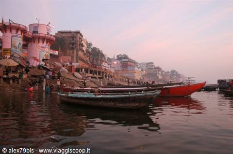 Wooden boats on the Ganges river in Varanasi, pink ghats in morning haze
